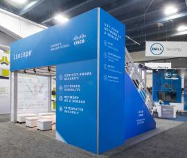 RENTAL: Modified RE-9073 Small Deck Design with Built-In Storage Closet, Angled Stair Case Graphics, SEG Graphic Frames Surrounding Deck Structure, (3) RE-1224 Square Pedestal Kiosks, RE-1229 Large Monitor Kiosk, Can Lights for Lower Level Meeting Area, R