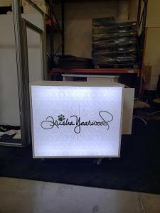 Custom Gravitee One-Step Inline Exhibit with (16) Shelves, Tension Fabric Graphics, MOD-1590 Backlit Counter with Storage, and a MOD-412 Counter with Additional Shelves