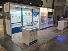 RENTAL: Custom Inline Design with Storage Closet with Locking Door, Ceiling Soffit with Recessed Puck Lighting, Custom Inset Shelving, Large Monitor Mount, 55&rdquo; Monitor, RE-1575 Square Counter, RE-1576 Rectangular Counter, Clear Acrylic Product Display C