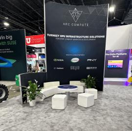 RENTAL: Modified RE-9097 Island Design with 16&rsquo; High Gravitee System Storage Tower, (2) 16 ft. High Curved Walls, (2) Curved Bridged Headers, (3) RE-1575 White Laminated Workstation Counters, (4) RE-1576 White Laminated Counters, (2) RE-703 Charging Sta