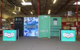 Modified GK-2012 Gravitee Modular Exhibit with Tension Fabric Graphics, SuperNova Lightbox, (9) Shelves, Closet, Wireless Charging Pads, and (2) MOD-1700C Backlit Reception Counters with Locking Storage