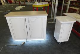 Custom Display Counters. (1) Reception Counter with LED Accent Lights, Vinyl Graphic and Locking Storage. (2) Product Display Counter with Grommet, Vinyl Graphic, and Castor Wheels -- View 2