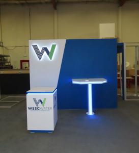Custom Reconfigurable Gravitee Modular Exhibit with Halo Lit Dimensional Logo, Puck Lights, Backwall Charging Table, MOD-1593 Square Counter with LED Lights, and MOD-1599 Counter with LED Accent Lights -- View 3