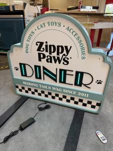 Custom Counter with RGBW LED Lights, Rounded Corners, Push-thru Backlit Logo, and Locking Storage and Freestanding Sign with LED Accent Lights -- View 4
