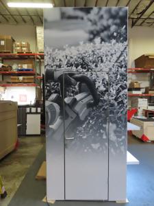 Custom Product Display Island with Gravitee Modular Closet, Tension Fabric Graphics, Interior and Exterior Shelves, Product Hooks, (4) Product Kiosks, (2) MOD-1584 Curved Reception Counters with RGB Lights, and Monitor Mount